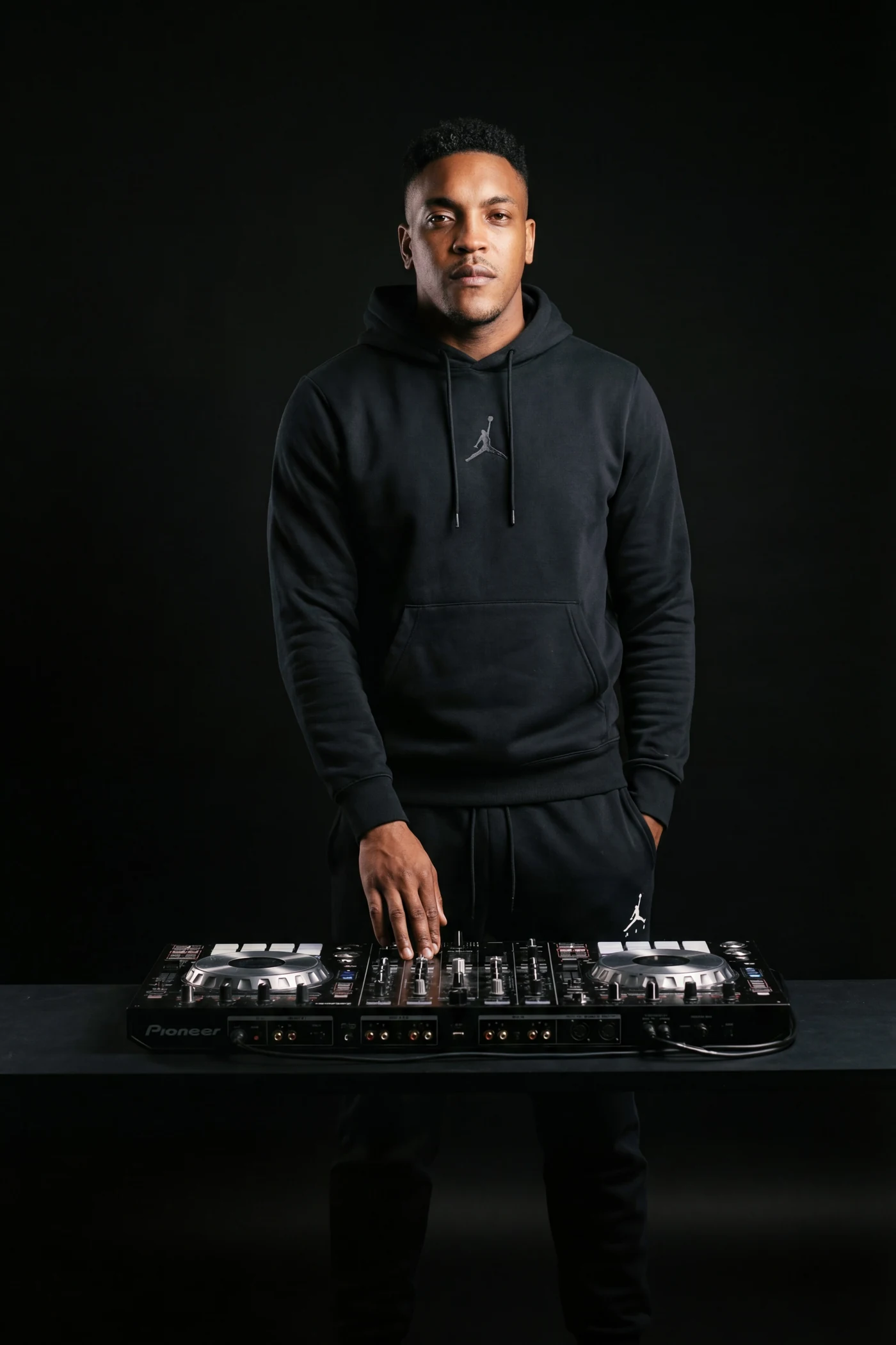 DJ King Halim am Pioneer DJ-Mixer, schwarzer Hoodie